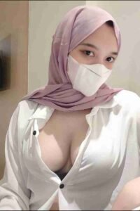 Malay Escort Girl Woman in hijab and mask wearing a revealing white shirt.