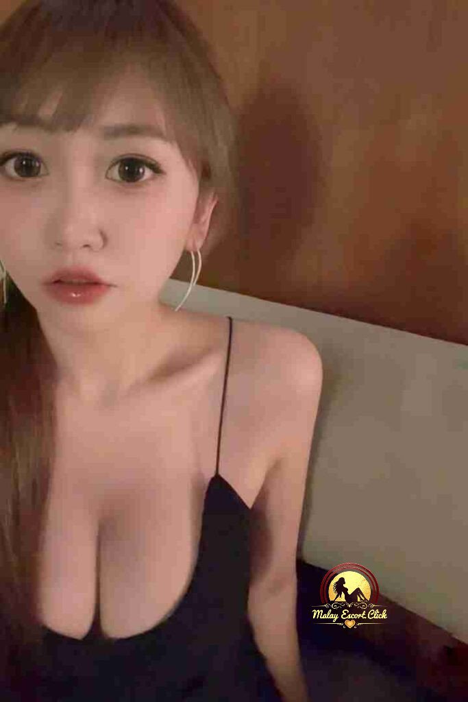 Attractive Asian woman with bangs in black dress. Kuala Lumpur escort services.