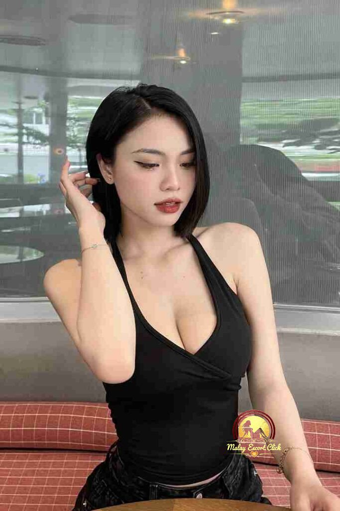 Attractive Asian woman with short black hair in a black halter top. Red lipstick. KL escort.