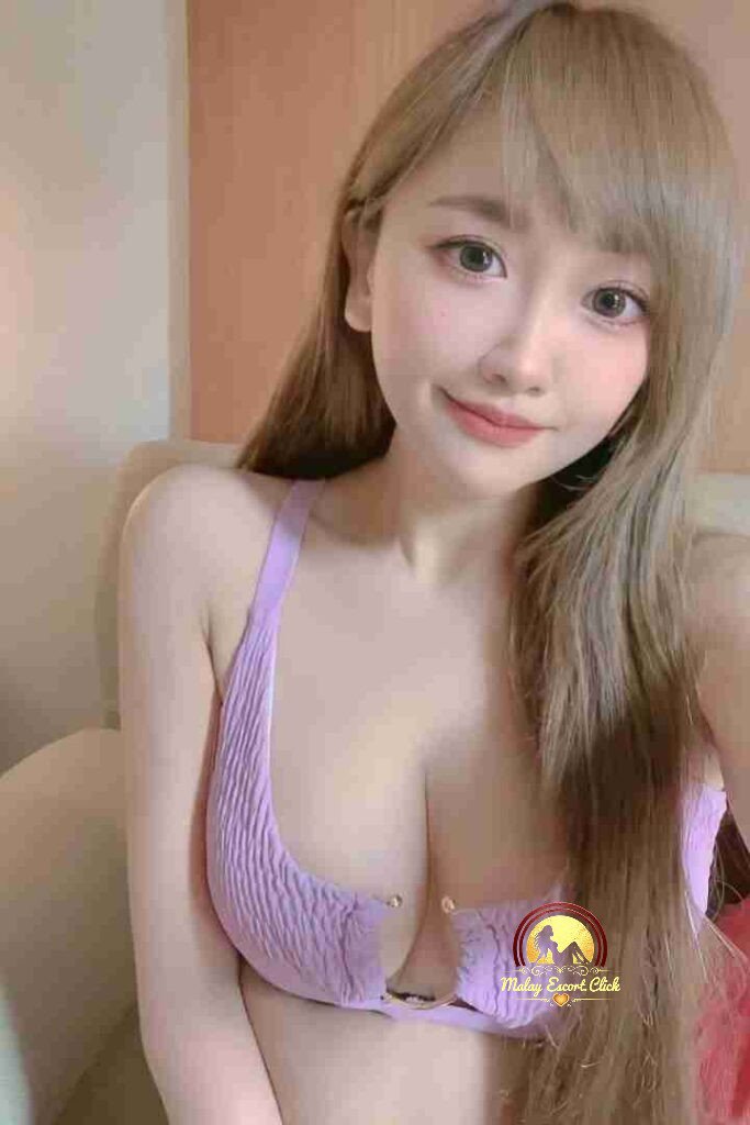 Attractive Asian woman with blonde hair in lavender top, smiling.