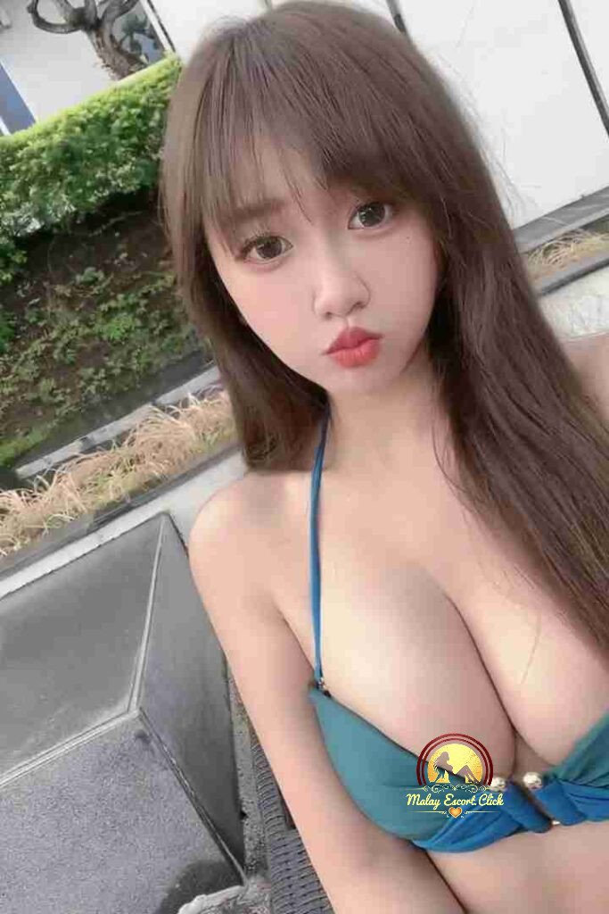 Attractive Asian woman with long brown hair in a blue bikini top. Pouting expression, looking at the camera.