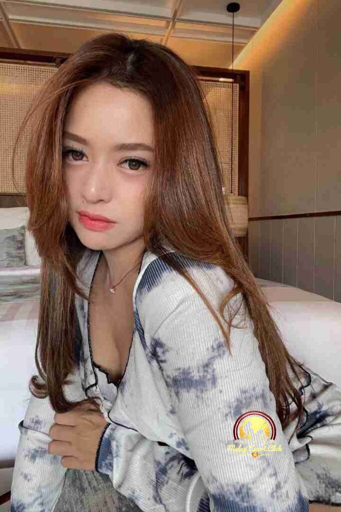 Malay Escort Girl Woman in hijab and mask wearing a revealing white shirt.