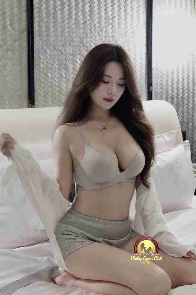 Malay Escort Girl Woman in hijab, lace top, and mask sits on stairs.