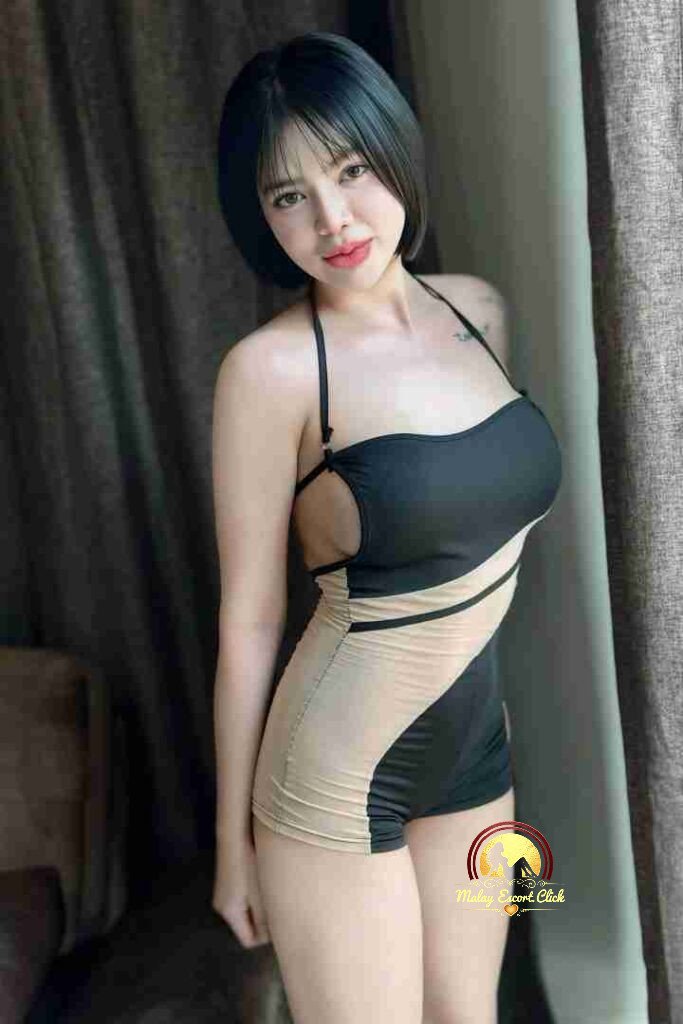 Attractive Asian woman in stylish black and beige swimsuit posing near curtains. Bob haircut, fair skin.