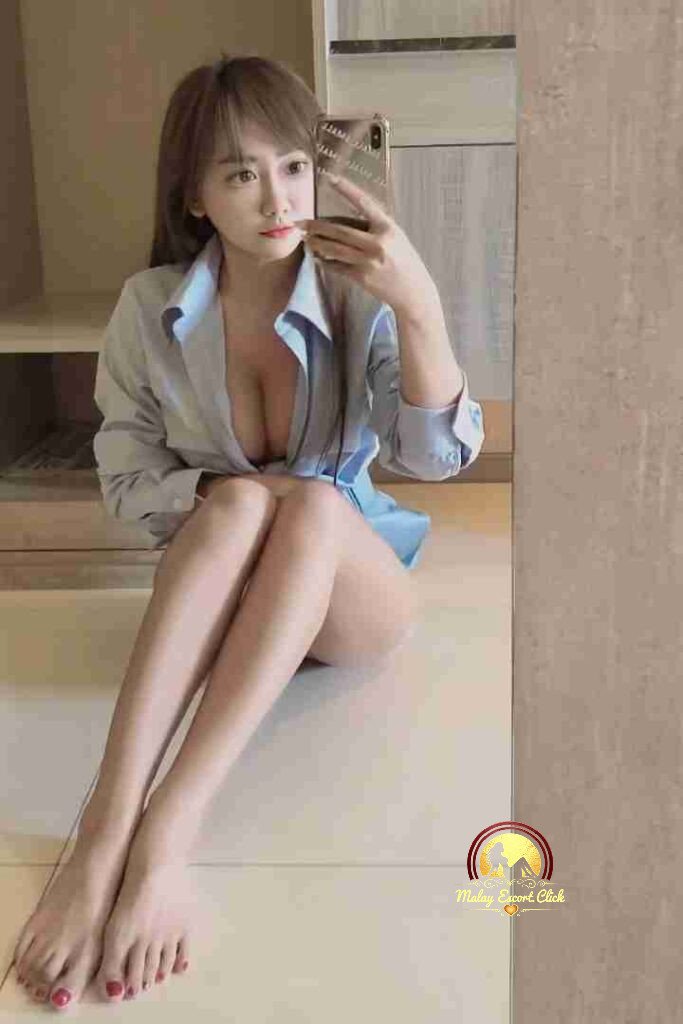 Attractive Asian woman in unbuttoned shirt taking selfie in Kuala Lumpur.