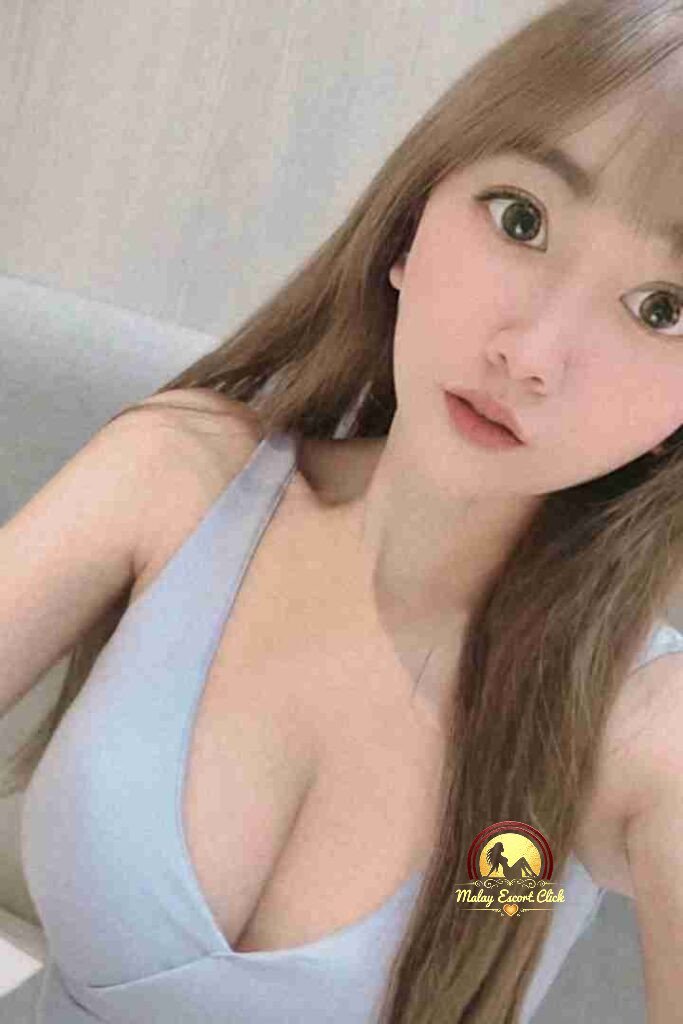 Attractive Asian woman with light brown hair and a blue top.