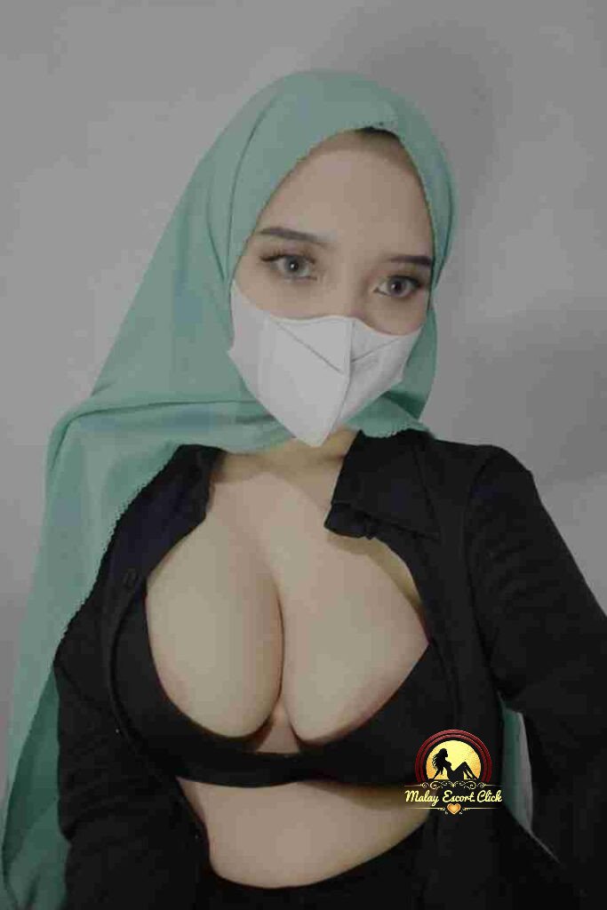 Malay Escort Girl Woman in anime shirt and lingerie kneeling indoors.