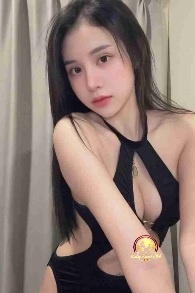 Malay Escort Girl Woman in denim bustier and jeans posing against a wall.