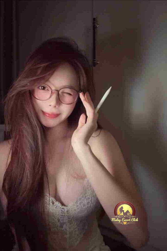 Pretty Vietnamese woman with glasses winking, holding a stylus. C cup sophistication.