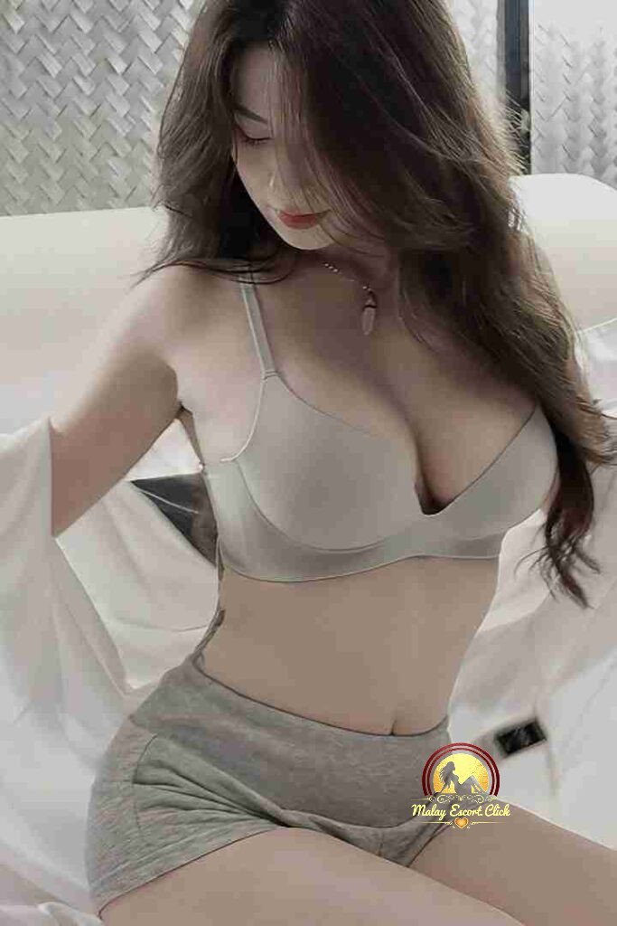 Attractive woman in bra and shorts, showcasing youthful beauty and a relaxed pose.