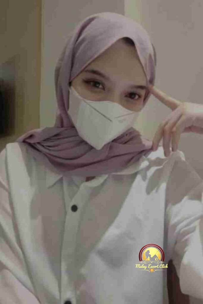 Malay Escort Girl Woman in anime shirt and lingerie kneeling indoors.