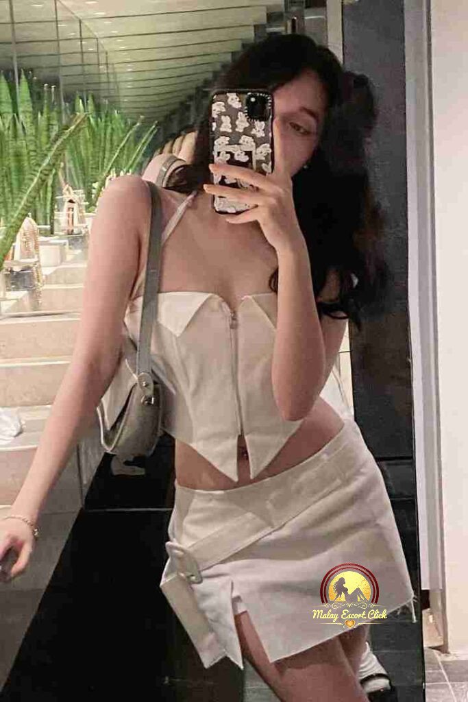 Woman in white halter top and mini skirt takes mirror selfie. C cup sophistication.